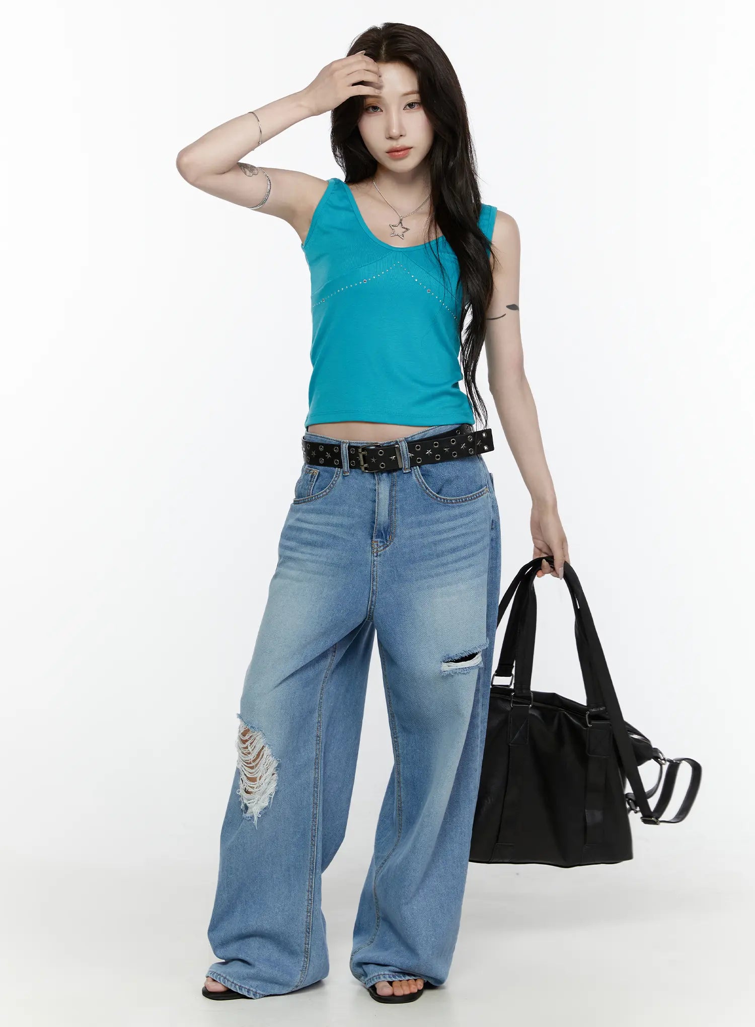 Arden Distressed High-Waist Baggy Jeans IL522 Blue front full-length on model in teal crop top hand in hair holding black tote bag with belt styling