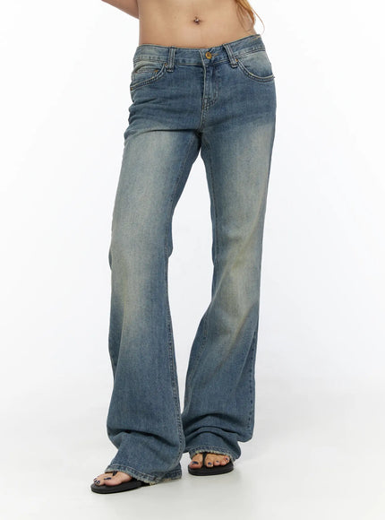 Arian Loose Flared Jeans CL528 Blue front close-up on model showing low-rise waistband, gold button, coin pocket, and vintage faded wash denim texture