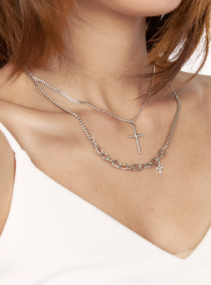 Arlo Cross Necklace IL522 Silver side close-up on model showing textured cross pendant on curb chain layered styling angled view on neckline