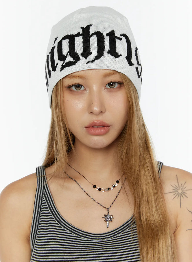 LEWKIN Aspen 1988 beanie IL503 White front close-up on model facing camera wearing knit beanie with black gothic letter jacquard