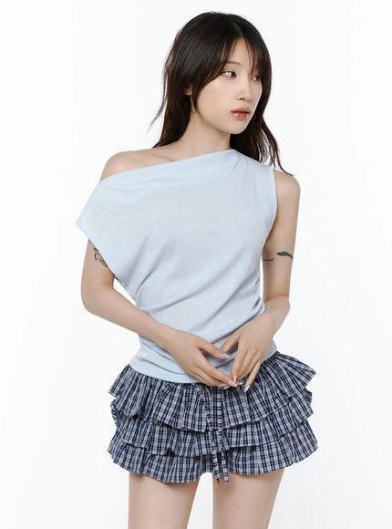 Asymmetric Off-Shoulder Top IL506 Light blue front model shot gazing sideways hands clasped at waist revealing off-shoulder detail and fitted body