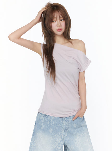 Asymmetric One-Shoulder Top IU525 light pink front close-up on model hand in hair paired with light wash floral denim shorts