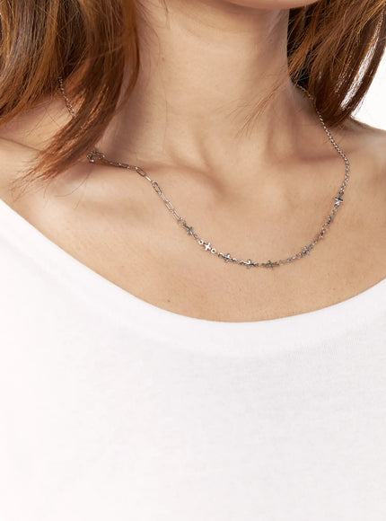 Atlas Cross Necklace IL517 silver on-model close-up worn on neck over white top showing cross charms at collarbone level