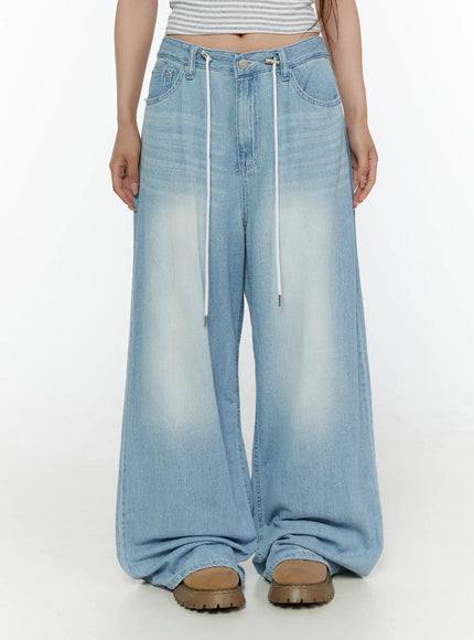 Aurelie Drawstring Washed Wide Leg Jeans CL507 Light blue front shot on model showing full length wide leg fit with white drawstrings and hem pooling over boots