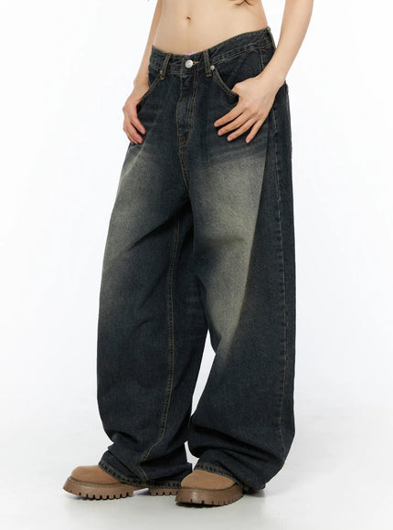 Avie Vintage Wash Wide Leg Jeans CU530 Dark blue side view on model hand in pocket highlighting wide-leg silhouette yellow-tinted fading and low-rise waist