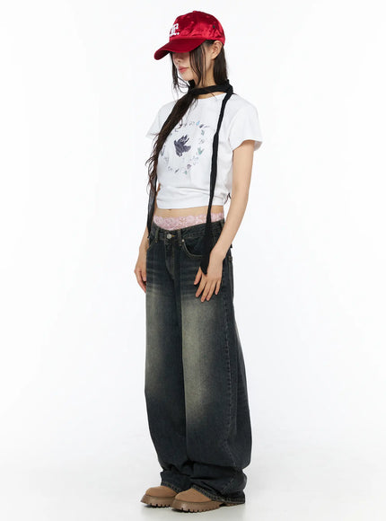 Avie Vintage Wash Wide Leg Jeans CU530 Dark blue side full-body view on model with red cap white graphic crop tee lace waistband and oversized wide leg pooling at hem