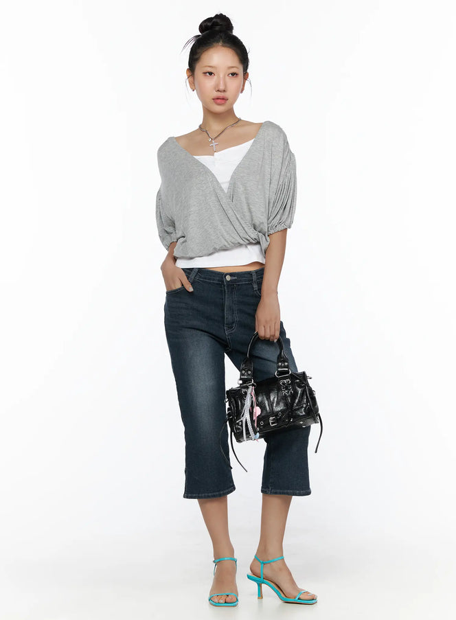 LEWKIN Axel Slit Capri Jeans CL510 dark blue full-length front shot on model wearing gray wrap top, holding black bag with teal heeled sandals