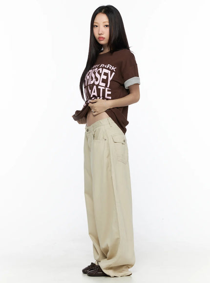 Back Pocket Wide Leg Pants CL524 Beige side full-length on model lifting tee to show low-rise waistband detail and side flap pocket hardware