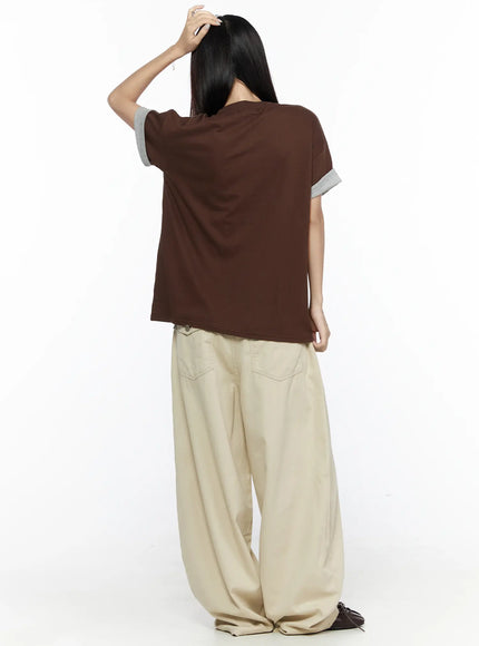 Back Pocket Wide Leg Pants CL524 Beige back full-length on model styled with brown tee, model holding hair up, showing back pockets and wide-leg drape