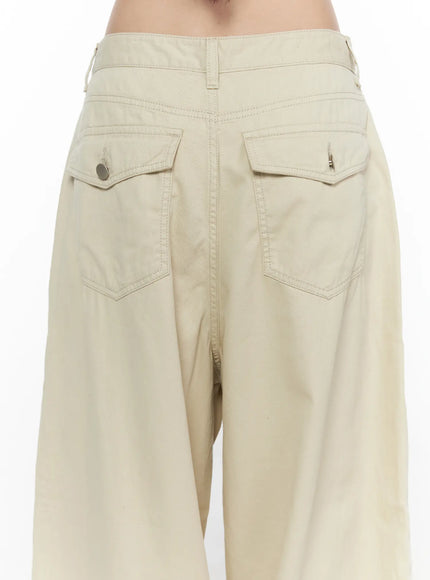 Back Pocket Wide Leg Pants CL524 Beige close-up back detail on model showing double flap pockets with button and clip hardware, contrast stitching