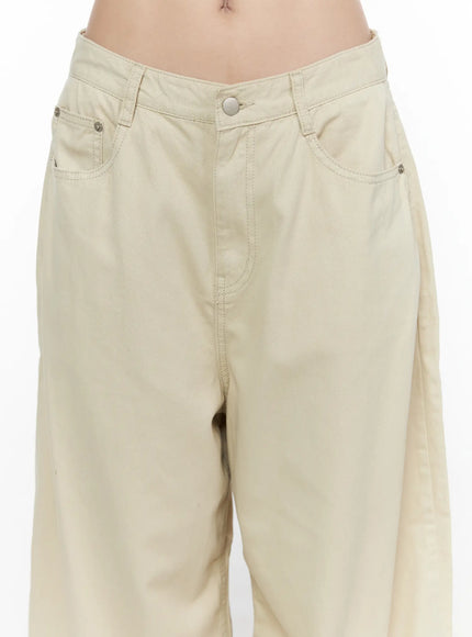 Back Pocket Wide Leg Pants CL524 Beige close-up front detail on model showing low-rise waistband, silver button, front pocket stitching, and cotton texture