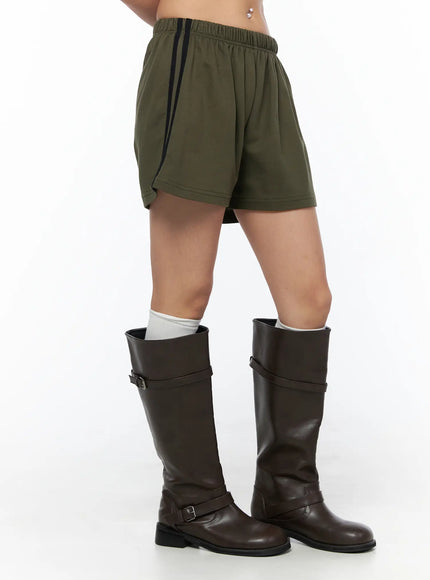 Banded Cotton Shorts CU524 Dark green close-up side shot on model showing elastic waistband and black side stripe detail with boots