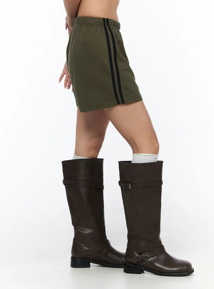 Banded Cotton Shorts CU524 Dark green side shot on model highlighting double black stripe tape running full length of shorts with boots
