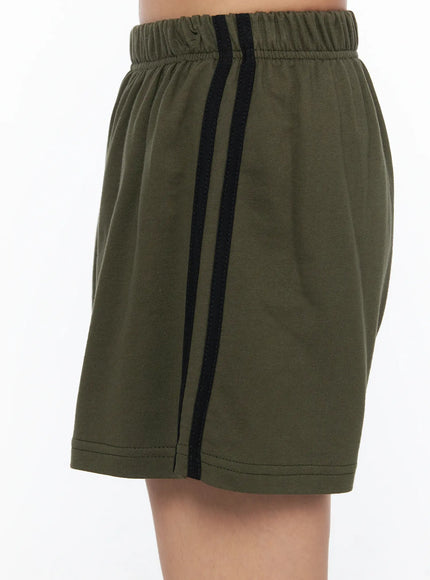 Banded Cotton Shorts CU524 Dark green close-up detail shot highlighting double black side stripe, elastic waistband, and cotton fabric texture