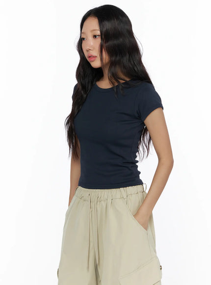 Basic Crewneck Tee CL510 Dark blue three-quarter front shot on model looking to the side, showing slim ribbed fit and cropped length over beige cargo pants