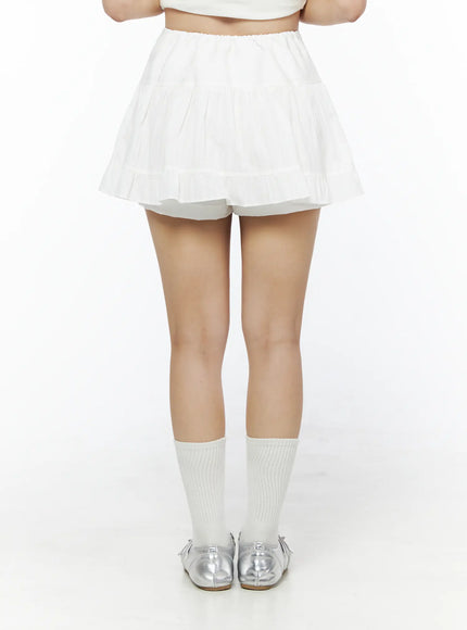 Basic Frill Flare Mini Skirt IU525 White back model shot waist-down showing elastic waistband tiered pleated back silhouette with built-in shorts visible at hem