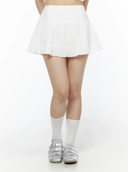 Basic Frill Flare Mini Skirt IU525 White front model shot waist-down standing straight showing tiered pleated flare hem with white socks and silver sandals