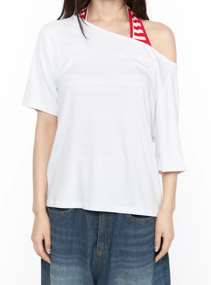Basic Loose Fit Asymmetric Tee CL522 White close-up front shot on model showing asymmetric one-shoulder neckline with red striped bra strap detail and cotton texture