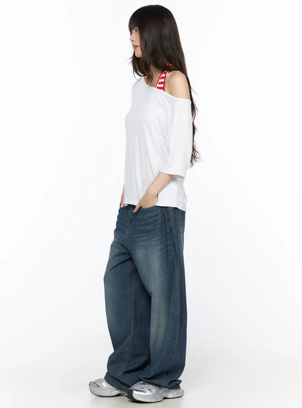 Basic Loose Fit Asymmetric Tee CL522 White side shot on model showing asymmetric shoulder drop and red striped inner strap detail with wide-leg denim