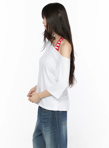 Basic Loose Fit Asymmetric Tee CL522 White close-up side shot on model highlighting asymmetric cold-shoulder cut and red striped bra strap layering detail