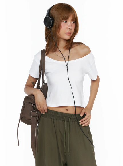 Basic Off-Shoulder Crop Tee CL503 White front shot on model wearing black headphones carrying brown shoulder bag styled with olive wide-leg pants