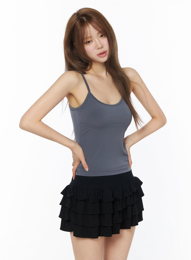 Basic Padded Cami Top IU525 grey front shot on model with hands on hips, paired with black tiered ruffle mini skirt, three-quarter crop view