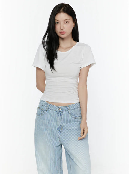 Basic Round Neck Tee IL506 White three-quarter front model shot, relaxed arms-down pose showing fitted crop silhouette and soft knit texture with striped jeans