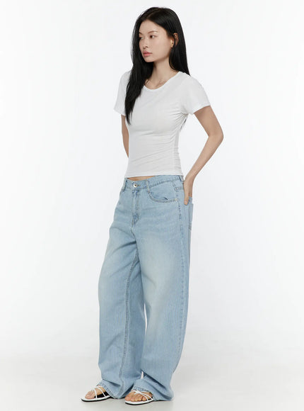 Basic Round Neck Tee IL506 White side model shot showing slim crop silhouette, short sleeve cut, and ruched side detailing paired with light blue striped denim