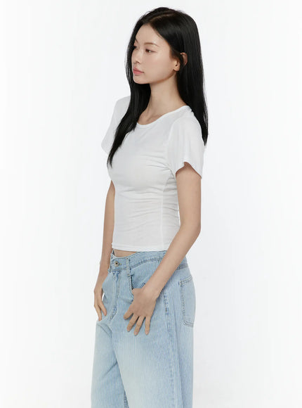 Basic Round Neck Tee IL506 White side profile model shot highlighting cropped hem, ruched waist seam, and slim short sleeve fit with striped denim