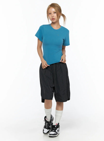 Basic Short Sleeve Top CU523 Blue S/M — front full-body shot, model standing hands on waistband, blue crop tee styled with black shorts and sneakers