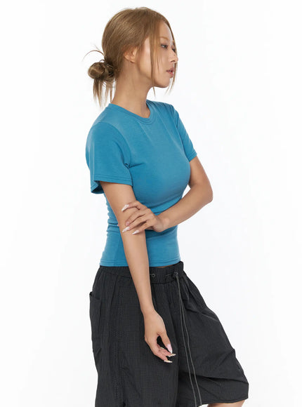 Basic Short Sleeve Top CU523 Blue S/M — side close-up shot, model arms crossed showing fitted silhouette and ribbed hem detail of blue tee
