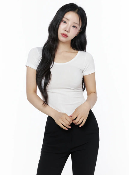 Basic U-Neck Tee IU525 White front shot on model hands clasped at waist scoop neckline ribbed stretch fabric with black pants