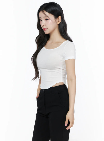 Basic U-Neck Tee IU525 White side close-up shot on model showing curved asymmetric hem crop length ribbed knit texture with black pants