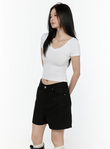 Basic V-Neck Crop Top IL506 White three-quarter side view on model looking down hand in pocket showing side seam and cropped fit