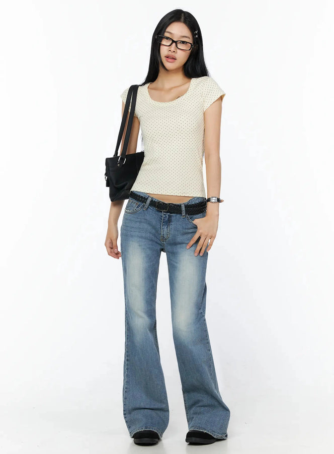 Bay Low Rise Bootcut Jeans IL509 Blue full-length front shot on model styled with cream polka dot top black shoulder bag glasses and braided belt