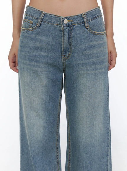 Beau Low-Rise Wide Jeans CL510 Blue close-up front detail on model showing V-shaped low-rise waistband, button closure, and gold contrast stitching
