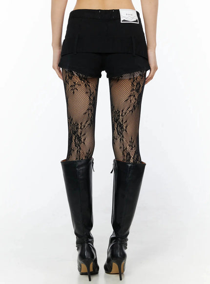 Belt Detail Micro Shorts IL509 Black back view on model showing ecru brand label, layered hem, back pockets and floral fishnet tights