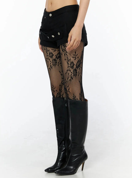 Belt Detail Micro Shorts IL509 Black side view on model showing cargo pocket and silver snap button detail over floral lace fishnet tights