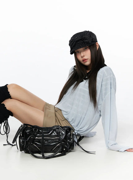 Belted Mini Skirt CL514 Beige lifestyle shot on seated model in light blue top and studded cap with black biker bag on floor