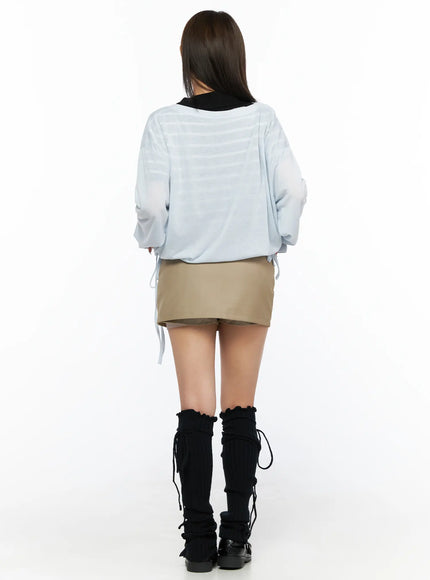 Belted Mini Skirt CL514 Beige full-body back shot on model in light blue sheer top showing skirt rear panel and belt loops with leg warmers
