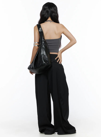 Belted Pintuck Wide Slacks CL510 black full-length back shot on model carrying leather shoulder bag with silver arm cuff accessory
