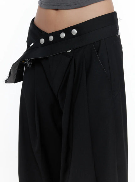 Belted Pintuck Wide Slacks CL510 black side close-up showing crossover snap-button waistband detail and wide-leg pleat silhouette on model