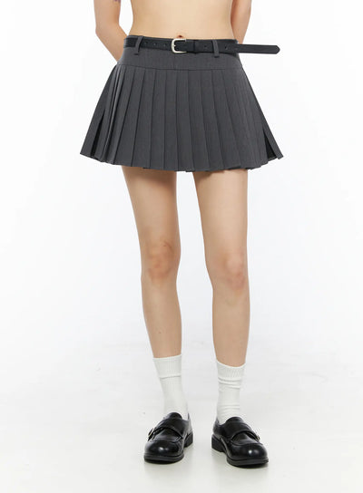 LEWKIN Belted Pleated Skirt CU530 Dark gray front crop shot on model size S with black leather belt white socks black loafers hands behind back