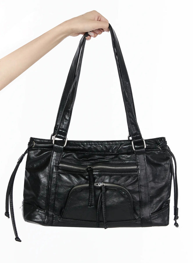 LEWKIN Black Zipper Shoulder Bag IL523 Black front view hand-held shot showing crinkled faux leather body dual shoulder straps silver zippers and side drawstring cords