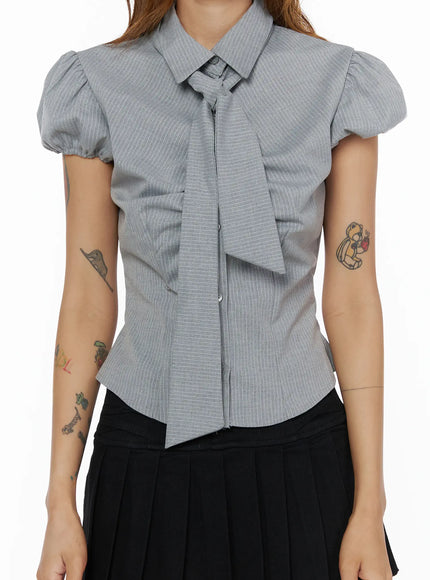 Bow Detail Puff Blouse CL503 Gray close-up front detail shot on model, collar with bow tie, button placket, puff sleeve cuff, pinstripe woven fabric texture visible