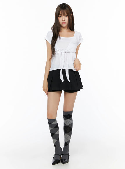 Bow-Detail Tank Set IL523 White S/M full-body front shot on model, front-tie bow waist, square neckline, soft jersey top styled with black mini skirt and argyle knee-high socks