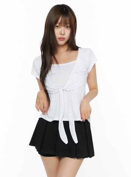 Bow-Detail Tank Set IL523 White S/M half-body front shot on model, relaxed arms-down pose, front-tie bow waist detail, square-neck tank layer, soft draped fabric, black mini skirt