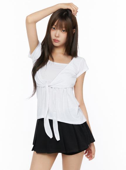 Bow-Detail Tank Set IL523 White S/M front shot on model with arm raised, angled view showing square neckline, front-tie bow, gathered skirt hem, cap sleeve styling