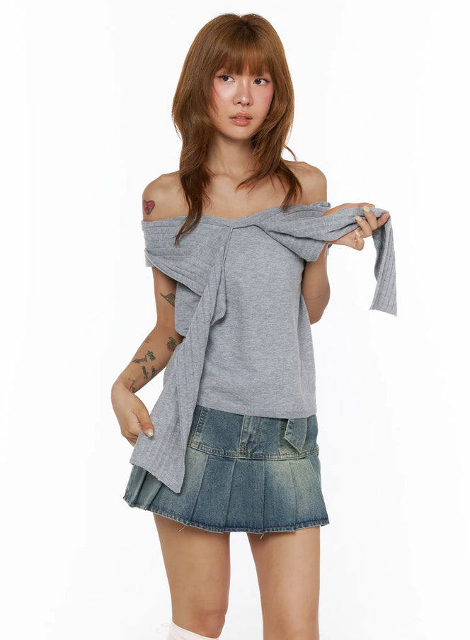 Bow Off-Shoulder Top CL503 Gray front view on model holding bow tie detail, ribbed off-shoulder silhouette, styled with denim mini skirt, dynamic styling pose
