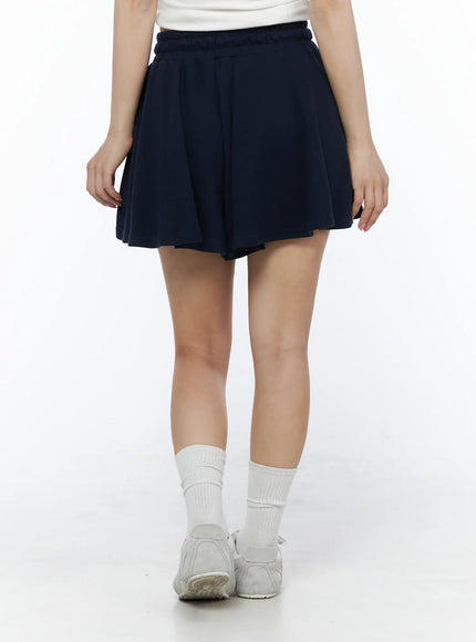 Brooklyn Grahic Tee & Mini Skort Set IU525 Dark blue lower-body front shot on model showing navy pleated mini skort hem drape and white crew socks